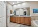 Elegant bathroom with a large mirror over double sinks, granite countertops, and a view of the soaking tub at 2676 Tanglewood Trl, Palm Harbor, FL 34685
