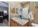 Bathroom featuring a wood vanity with granite countertop and a large mirror reflecting a bedroom at 2676 Tanglewood Trl, Palm Harbor, FL 34685