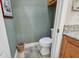 This half bathroom features a standard toilet, neutral paint, and a decorative trash bin at 2676 Tanglewood Trl, Palm Harbor, FL 34685