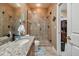 Modern bathroom featuring a granite countertop vanity and a large glass-enclosed shower; open to an adjacent room at 2676 Tanglewood Trl, Palm Harbor, FL 34685