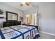 Comfortable bedroom featuring a blue and white quilt, dark wood dresser, and access to an en-suite bathroom at 2676 Tanglewood Trl, Palm Harbor, FL 34685