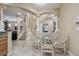 Breakfast nook features a modern glass table set, tile flooring, and views of the main living area and stairway at 2676 Tanglewood Trl, Palm Harbor, FL 34685
