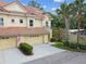 Charming townhome featuring a tile roof, one-car garage, well-maintained landscaping, and covered front entrance at 2676 Tanglewood Trl, Palm Harbor, FL 34685