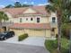 Charming two-story townhome with a tile roof, one-car garage, well-maintained landscaping, and covered front entrance at 2676 Tanglewood Trl, Palm Harbor, FL 34685