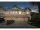 Charming townhome featuring a red tile roof, two-car garage, and well-maintained landscaping at dusk at 2676 Tanglewood Trl, Palm Harbor, FL 34685