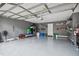 A spacious two car garage with newly painted floor, equipped with wall shelving, and an automatic garage door at 2676 Tanglewood Trl, Palm Harbor, FL 34685