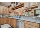 This updated kitchen includes granite countertops, wood cabinets, and stainless steel appliances with view into adjacent room at 2676 Tanglewood Trl, Palm Harbor, FL 34685