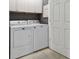 A dedicated laundry room with a washer, dryer, and white cabinets adds convenience to your home at 2676 Tanglewood Trl, Palm Harbor, FL 34685