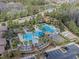 Beautiful aerial view of community pool, palm trees, water slide, clubhouse, and parking areas at 28923 Lucero Ln, Wesley Chapel, FL 33543