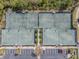 Aerial view of four tennis courts and parking lot surrounded by meticulously maintained landscaping and trees at 28923 Lucero Ln, Wesley Chapel, FL 33543