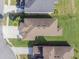 Detailed aerial view of rooftops, lush lawns, and landscaping in a residential neighborhood at 28923 Lucero Ln, Wesley Chapel, FL 33543