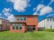 Spacious backyard featuring an extended patio with outdoor seating, a grassy lawn, and a charming two-story home at 28923 Lucero Ln, Wesley Chapel, FL 33543