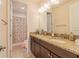 Bathroom featuring a dual sink granite vanity and shower and bath combination behind a floral curtain at 28923 Lucero Ln, Wesley Chapel, FL 33543