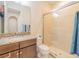Neutral toned bathroom featuring a granite vanity top, framed mirror and enclosed glass shower at 28923 Lucero Ln, Wesley Chapel, FL 33543
