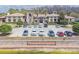 Exterior view of clubhouse with stone accents, well manicured lawn, palm trees, and parking spaces at 28923 Lucero Ln, Wesley Chapel, FL 33543