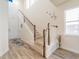 Bright foyer featuring wood-look floors, staircase with wood and white railings and lots of natural light at 28923 Lucero Ln, Wesley Chapel, FL 33543