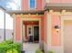 Inviting front porch with a black door, neutral columns, trimmed bushes, and a cozy seating area at 28923 Lucero Ln, Wesley Chapel, FL 33543