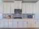 Modern kitchen with white cabinets, stainless steel appliances, and a stylish backsplash at 28923 Lucero Ln, Wesley Chapel, FL 33543
