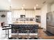 Modern kitchen featuring a large island with seating, sleek appliances, and white cabinetry at 28923 Lucero Ln, Wesley Chapel, FL 33543