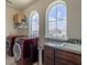 Functional laundry room with modern appliances, granite countertops, and bright, arched windows at 28923 Lucero Ln, Wesley Chapel, FL 33543