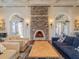 Inviting living room featuring a stone fireplace, hardwood floors, and elegant furnishings at 28923 Lucero Ln, Wesley Chapel, FL 33543