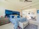 Bright main bedroom featuring a tray ceiling, blue accent wall, sitting area, and large windows at 28923 Lucero Ln, Wesley Chapel, FL 33543