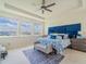 Bright main bedroom with a tray ceiling, large windows, blue accent wall, and stylish furnishings at 28923 Lucero Ln, Wesley Chapel, FL 33543