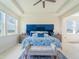 Bright main bedroom with a tray ceiling, large windows, blue accent wall, and stylish furnishings at 28923 Lucero Ln, Wesley Chapel, FL 33543