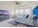 Bright main bedroom with a tray ceiling, large windows, blue accent wall, and modern furnishings at 28923 Lucero Ln, Wesley Chapel, FL 33543