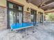 Outdoor covered patio area with a ping pong table and an outdoor dining area at 28923 Lucero Ln, Wesley Chapel, FL 33543