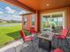 Covered patio featuring outdoor seating, a gas fire pit, and a peaceful view of the pond at 28923 Lucero Ln, Wesley Chapel, FL 33543