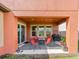 Inviting covered patio features a grill, a gas fire pit, outdoor seating, and a sliding glass door to the home at 28923 Lucero Ln, Wesley Chapel, FL 33543