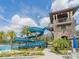 Community pool area features a winding water slide, palm trees, and lounge seating under a sunny sky at 28923 Lucero Ln, Wesley Chapel, FL 33543