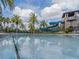 Community pool with waterslide, palm trees and inviting clear water at 28923 Lucero Ln, Wesley Chapel, FL 33543