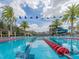 Resort-style pool with palm trees, water slide, and blue and white pennant banner at 28923 Lucero Ln, Wesley Chapel, FL 33543