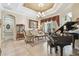 Elegant living room with high ceilings, chandelier, piano, and stylish furnishings at 3040 Olivia Ct, Land O Lakes, FL 34638