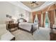 Elegant main bedroom featuring tray ceiling, large windows, and access to the pool area at 3040 Olivia Ct, Land O Lakes, FL 34638