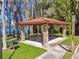 Covered picnic area with stone pillars, wooden tables, and a grill, creating a perfect spot for outdoor dining at 3040 Olivia Ct, Land O Lakes, FL 34638