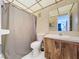 Cozy bathroom featuring a toilet, shower with curtain, vanity, and sink with mirror and butterfly wallpaper at 3914 41St W St, Bradenton, FL 34205