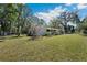 Quaint single-story home boasting a lush lawn, mature trees, and a welcoming front porch at 3946 Ernest Dr, Wesley Chapel, FL 33543