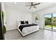 Bright bedroom with a ceiling fan, white walls, gray flooring and a sliding door to the backyard at 4036 56Th N Ave, St Petersburg, FL 33714