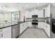 Modern kitchen with white cabinetry, stainless steel appliances, and a stylish backsplash at 4036 56Th N Ave, St Petersburg, FL 33714