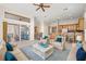 Open concept living room flows into kitchen with counter seating and relaxing sunroom with bright, neutral colors at 4949 Sandy Brook, Wimauma, FL 33598