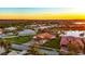Gorgeous sunset aerial view of single-Gathering homes with tile roofs, lush landscaping, and a serene lake at 5073 Stone Harbor Cir, Wimauma, FL 33598