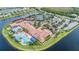 Aerial view showcases tennis courts, clubhouse, and pool, all nestled in a waterfront community at 5073 Stone Harbor Cir, Wimauma, FL 33598