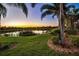 Manicured backyard featuring a pond view, palm trees, and lush landscaping at 5073 Stone Harbor Cir, Wimauma, FL 33598