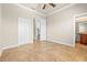 Spacious bedroom featuring neutral walls, tile flooring, ceiling fan, and natural light at 5073 Stone Harbor Cir, Wimauma, FL 33598