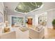Bright, open living room showcasing a decorative ceiling, tile floors, and backyard views at 5073 Stone Harbor Cir, Wimauma, FL 33598