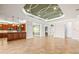 Spacious living room boasting tile flooring and decorative tray ceiling detail with open layout to kitchen at 5073 Stone Harbor Cir, Wimauma, FL 33598