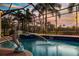 Relaxing screened-in pool area with a charming dolphin fountain statue and beautiful landscaping at 5073 Stone Harbor Cir, Wimauma, FL 33598